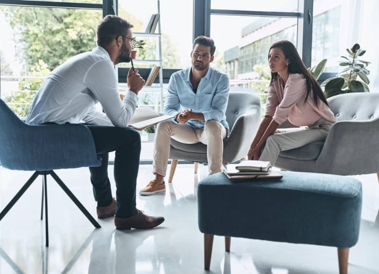 male mediator talking to a couple