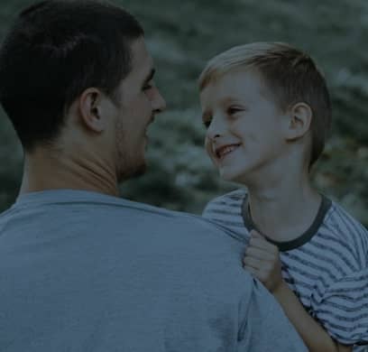father and young son smiling at each other