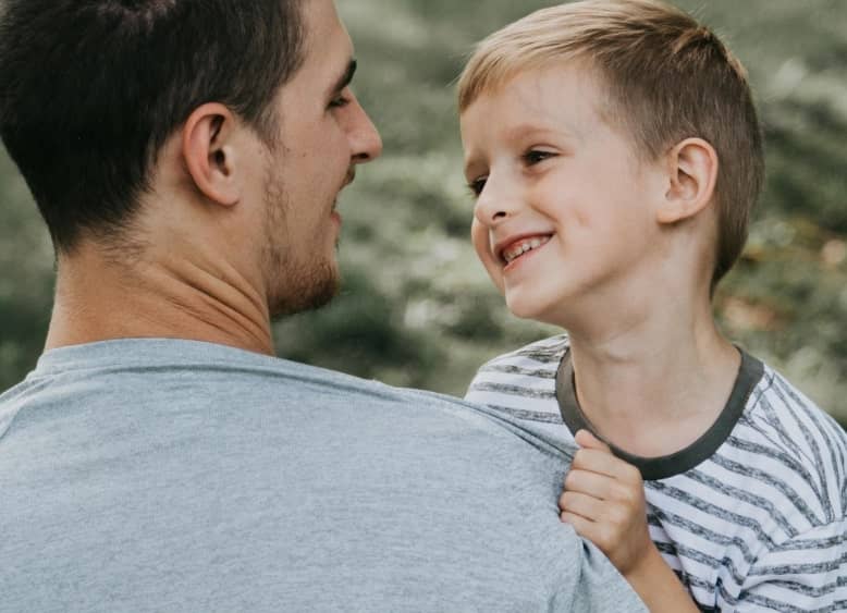 young boy looking at his father while smiling