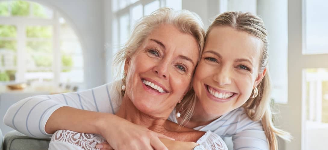 Women, hug and family bond on mothers day in a house living room and home interior