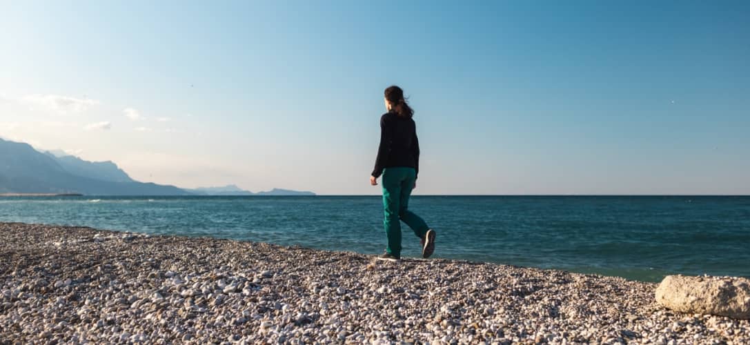 girl walks along the beach alone, a woman looks at the sea